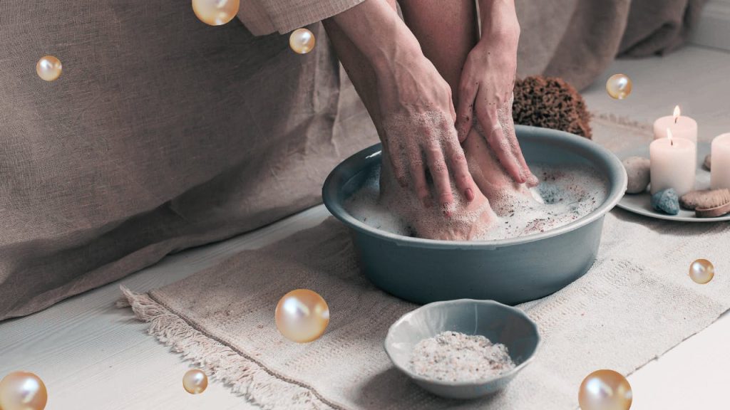A close up of a person washing their feet in a bowl.