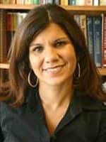 A dark-haired woman with big hoop earrings