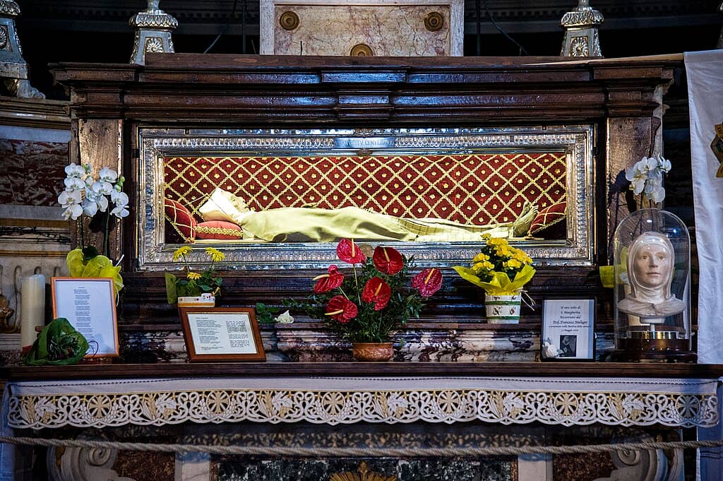 a corpse in a reliquary with flowers