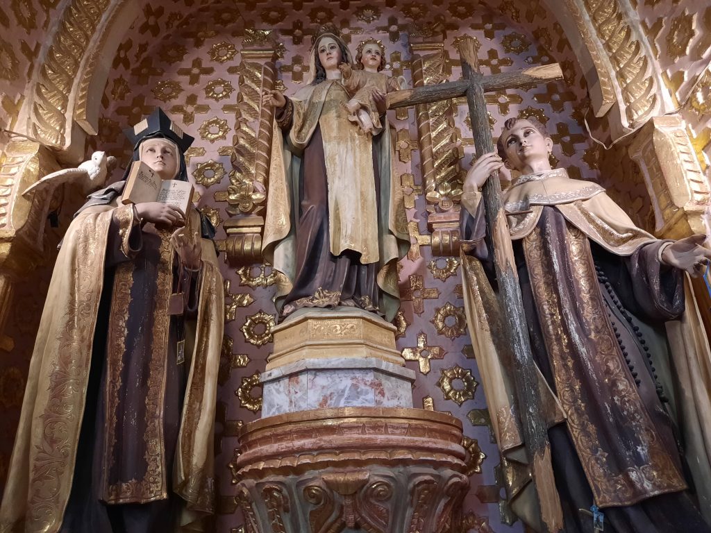 a church altar with Mary and the baby Jesus and a nun and a priest statues