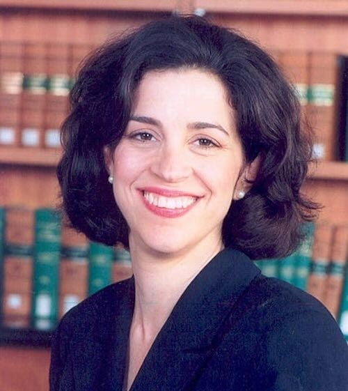 A portrait photo of Helen M. Alvare in front of a wall of books.