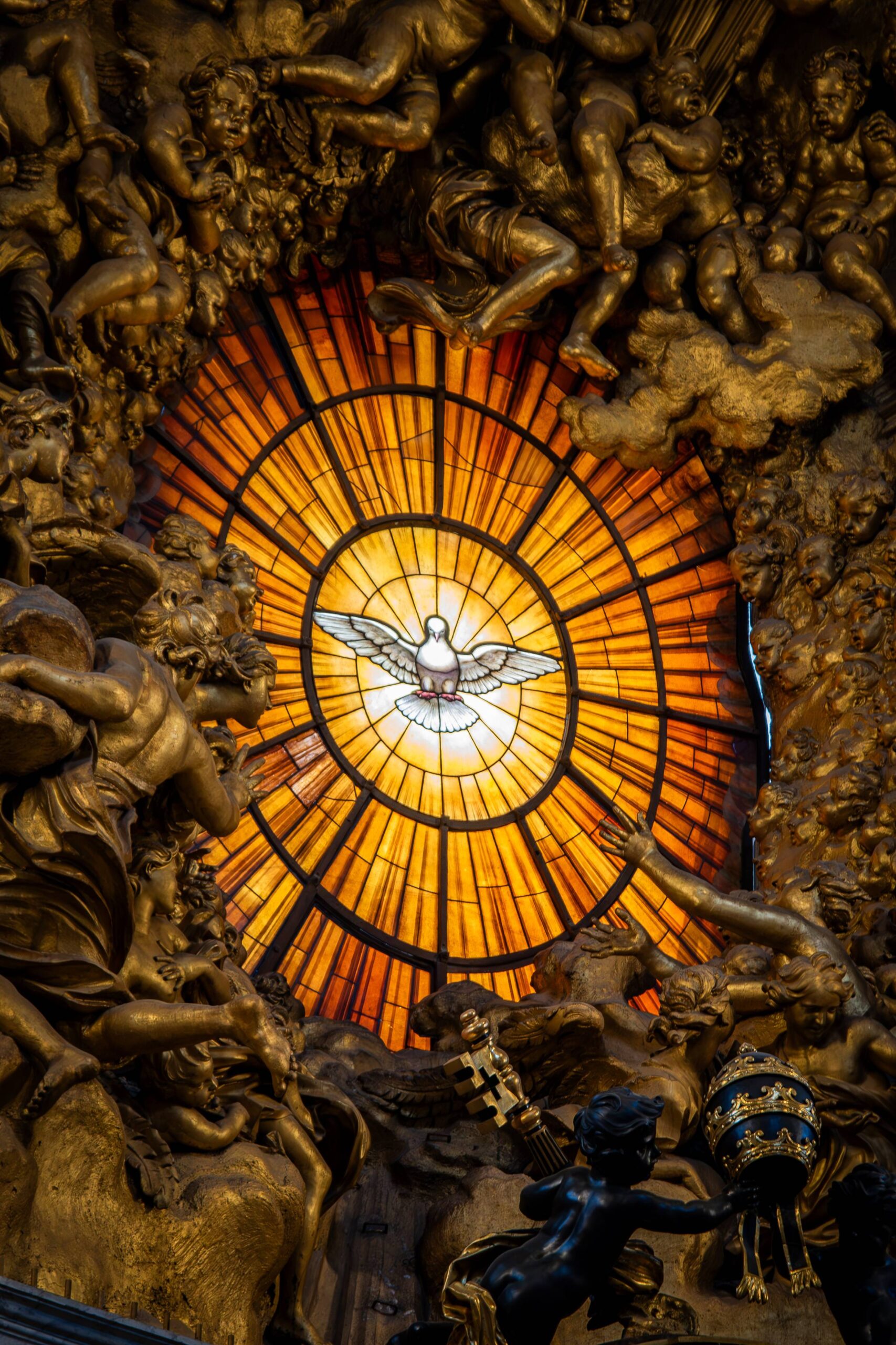 a white dove in a stained glass circle of yellow and orange with golden angels around it