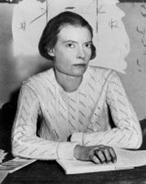 An image of Dorothy Day sitting behind a desk.