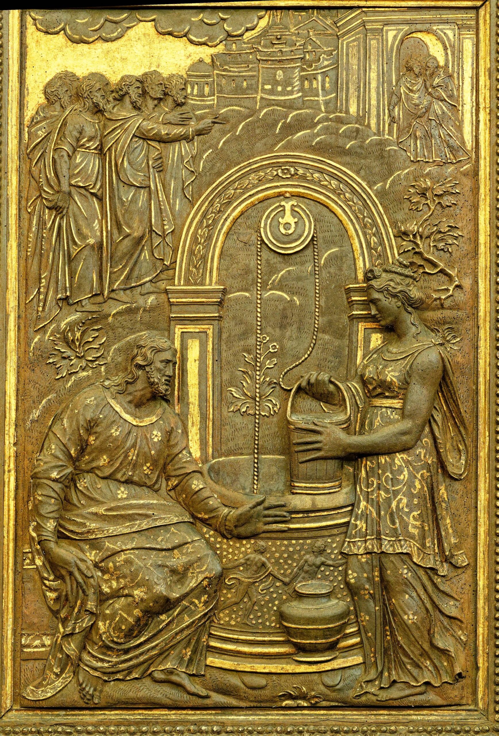 A gold relief sculpture showing a woman at the well with jesus
